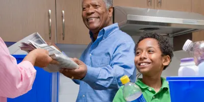 Opa leert jongen recyclen in keuken.